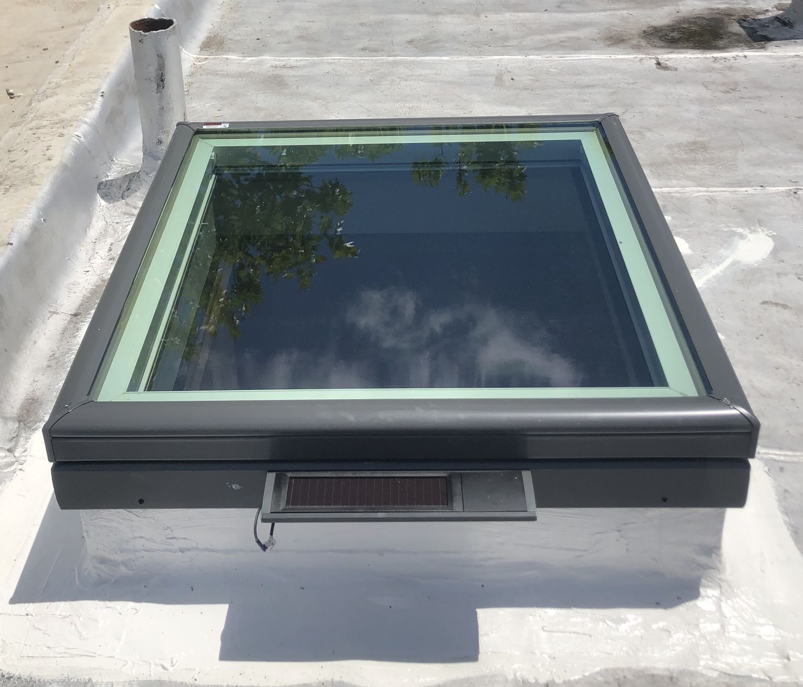 Solar venting skylight on a coated curb