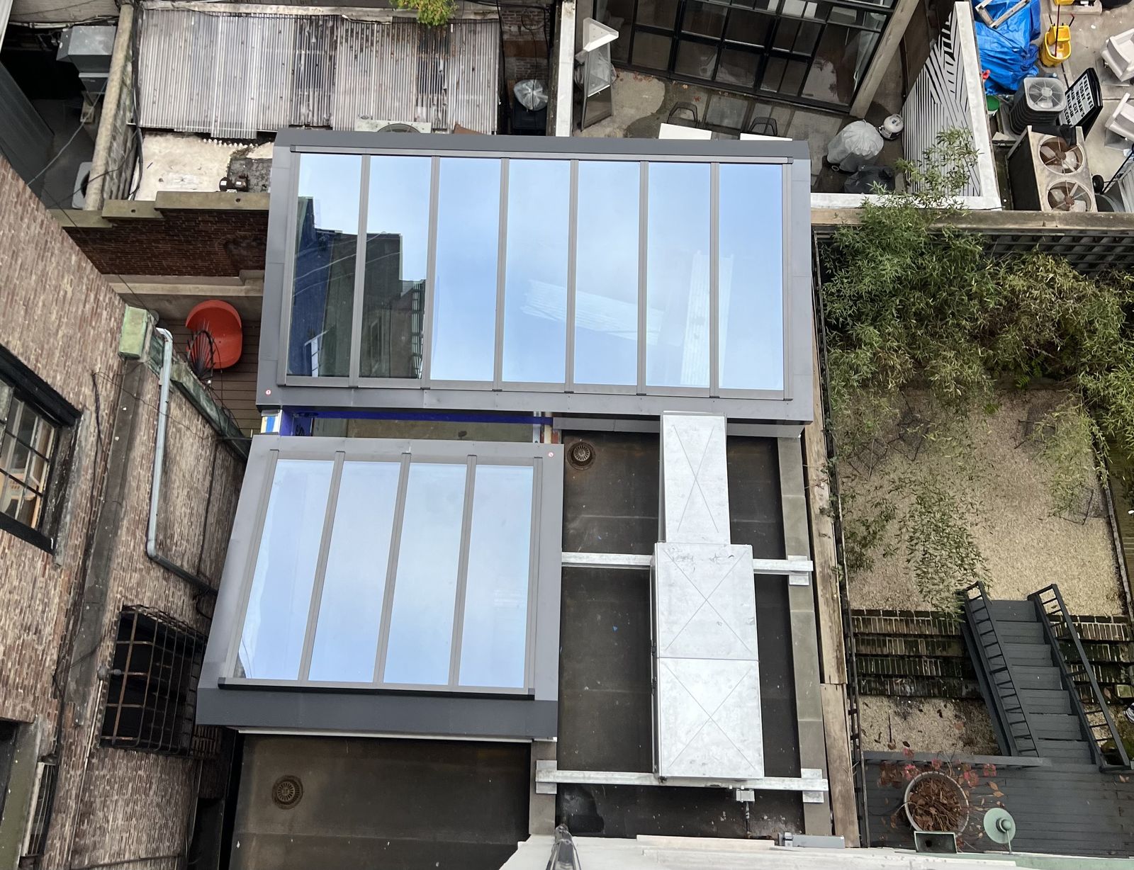 Twin flat-glass banks over a brownstone extension