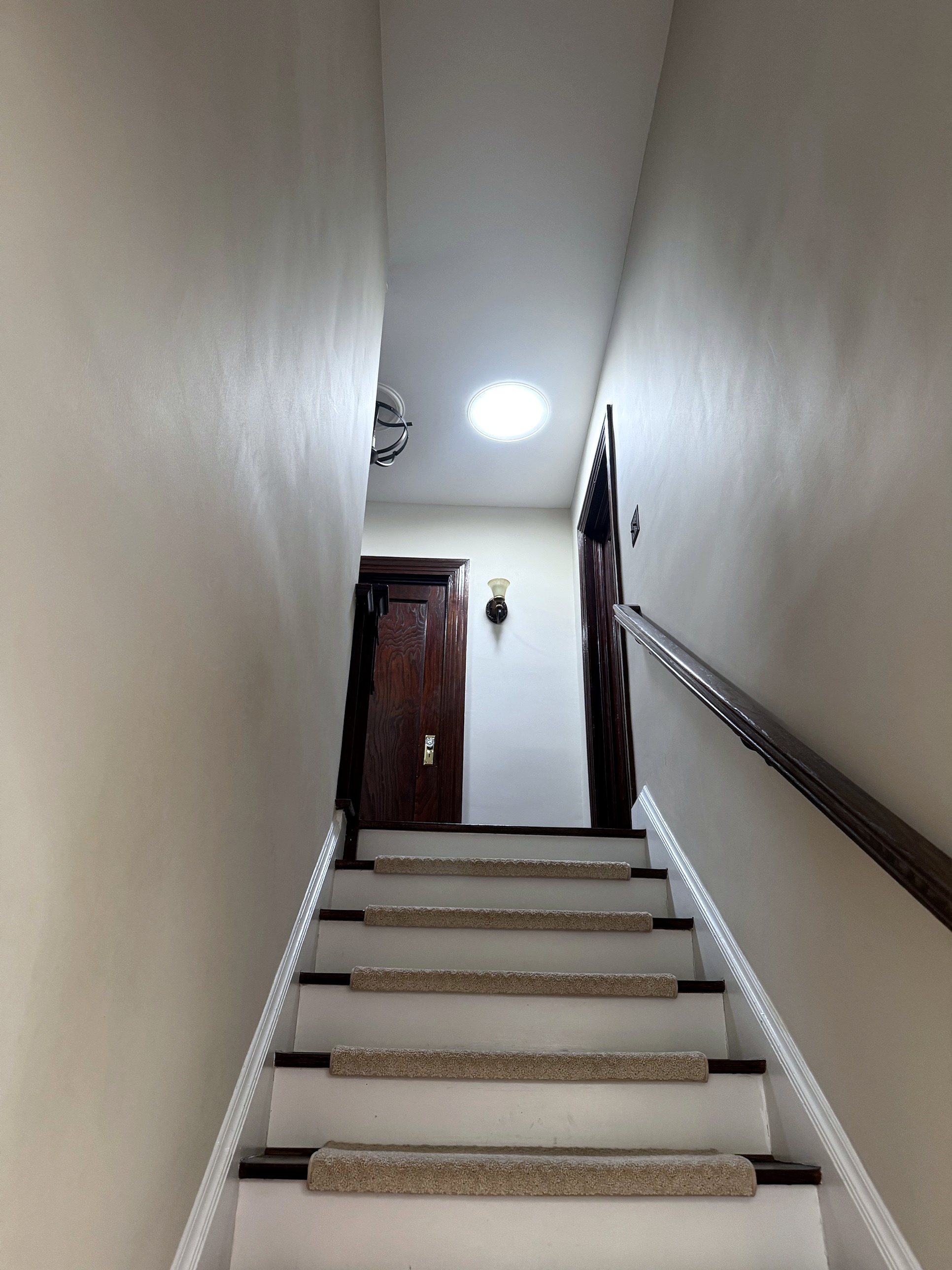 The same Staten Island stairwell after sun tunnels were installed, filled with daylight from a flush ceiling diffuser
